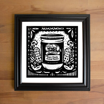 A framed print of a jar of Teddie Peanut Butter (chunky.)